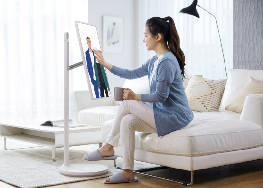 LG전자 모델이 LG 스탠바이미로 카카오웹툰이 제공하는 웹툰을 감상하고 있다.<LG전자 제공>